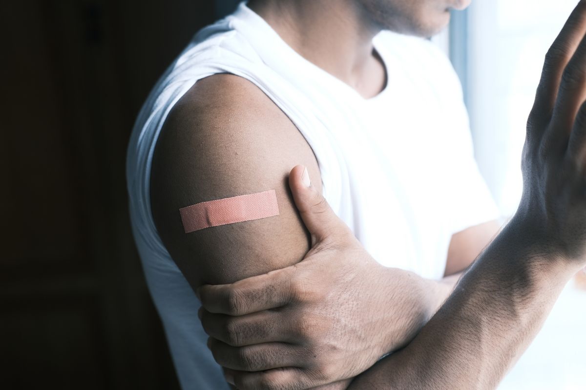 Adhesive bandage on an upper arm after a shot